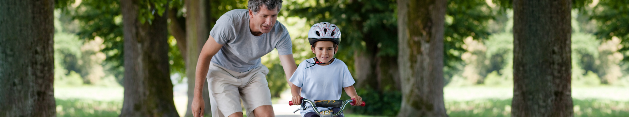 man helping a child ride a bike